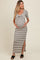 woman wearing a striped maternity maxi dress with a twisted front detail and side slit, holding her baby bump