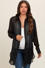 woman wearing a black sheer maternity button-up shirt over a white tank top and showing her baby bump