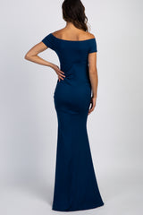 woman wearing a navy blue off-shoulder maternity dress with a fitted silhouette and fitted skirt