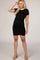 woman wearing a black short sleeve maternity dress with ruching, showing her baby bump