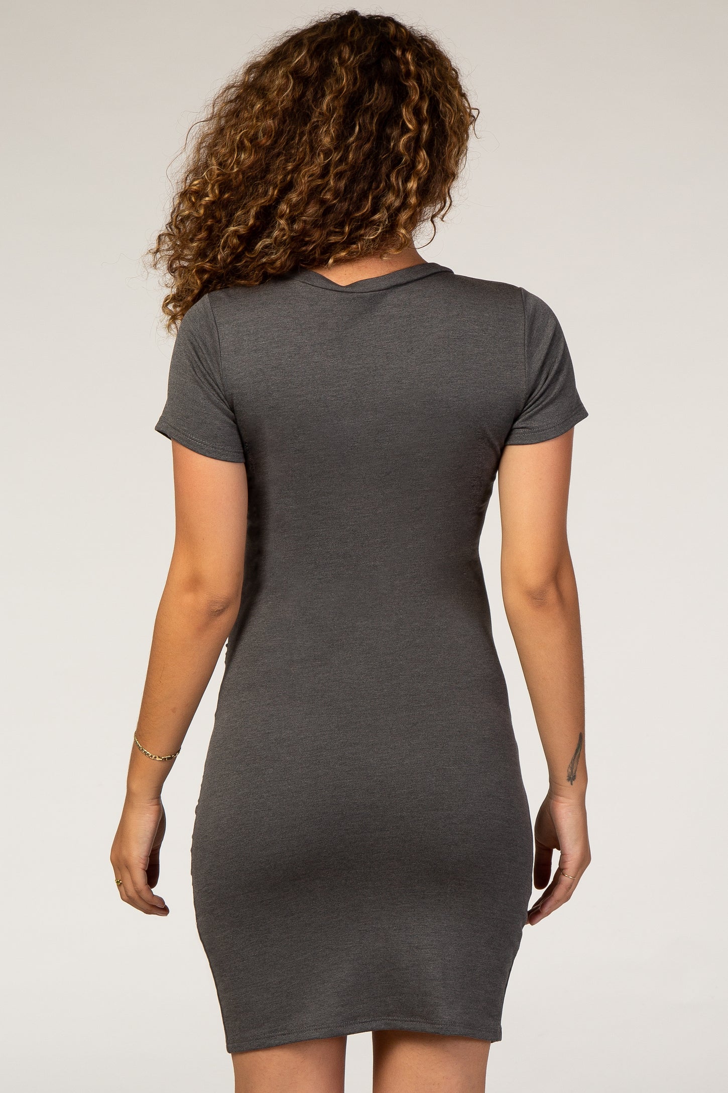 woman wearing a charcoal gray short sleeve maternity dress, viewed from the back
