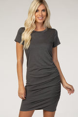 woman wearing a dark gray short sleeve fitted dress with gathered side details
