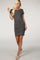 woman wearing a dark gray short sleeve fitted dress with side ruching and standing in a relaxed pose