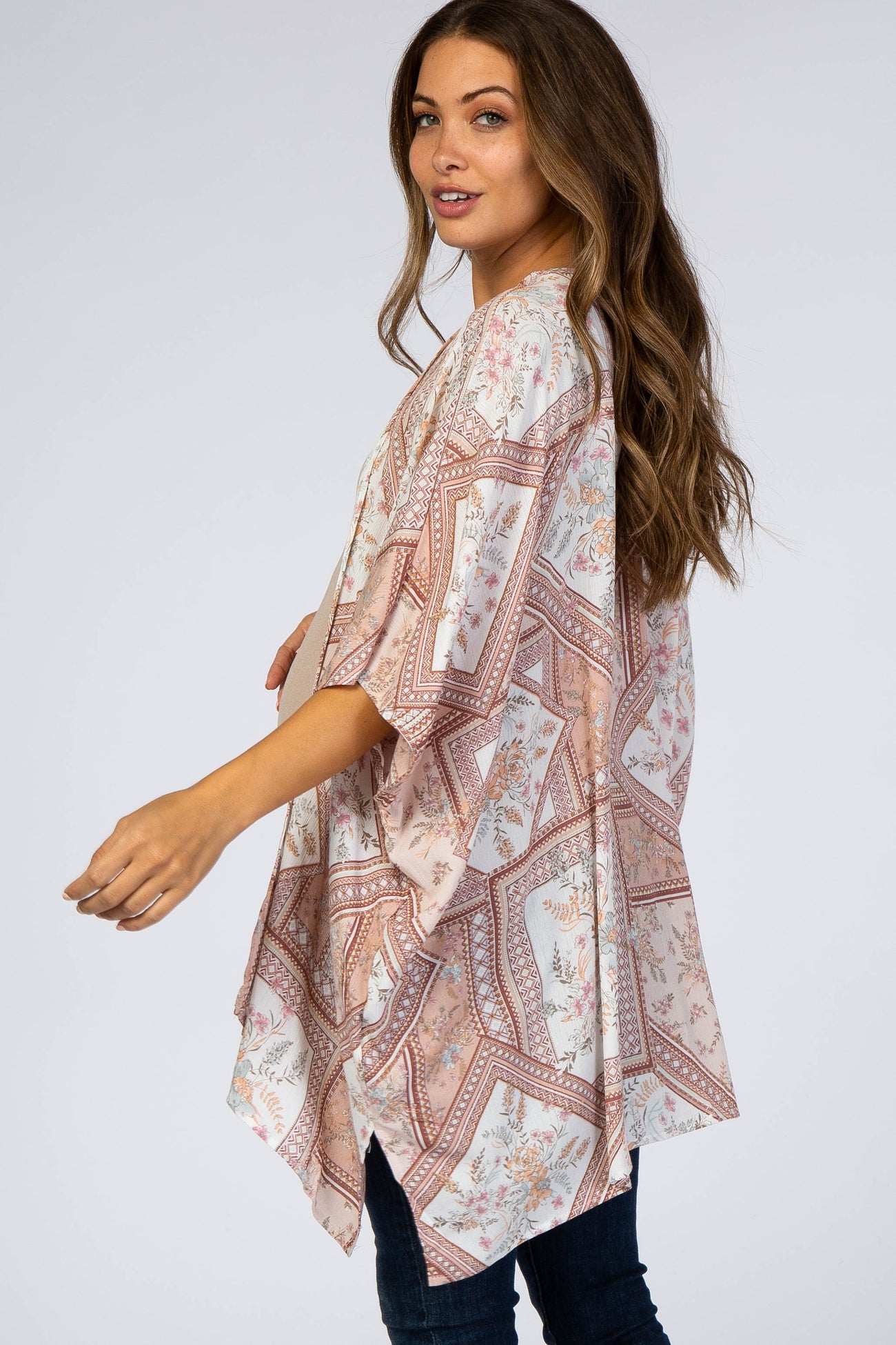 woman wearing a pink and white floral paisley print maternity kimono with wide sleeves